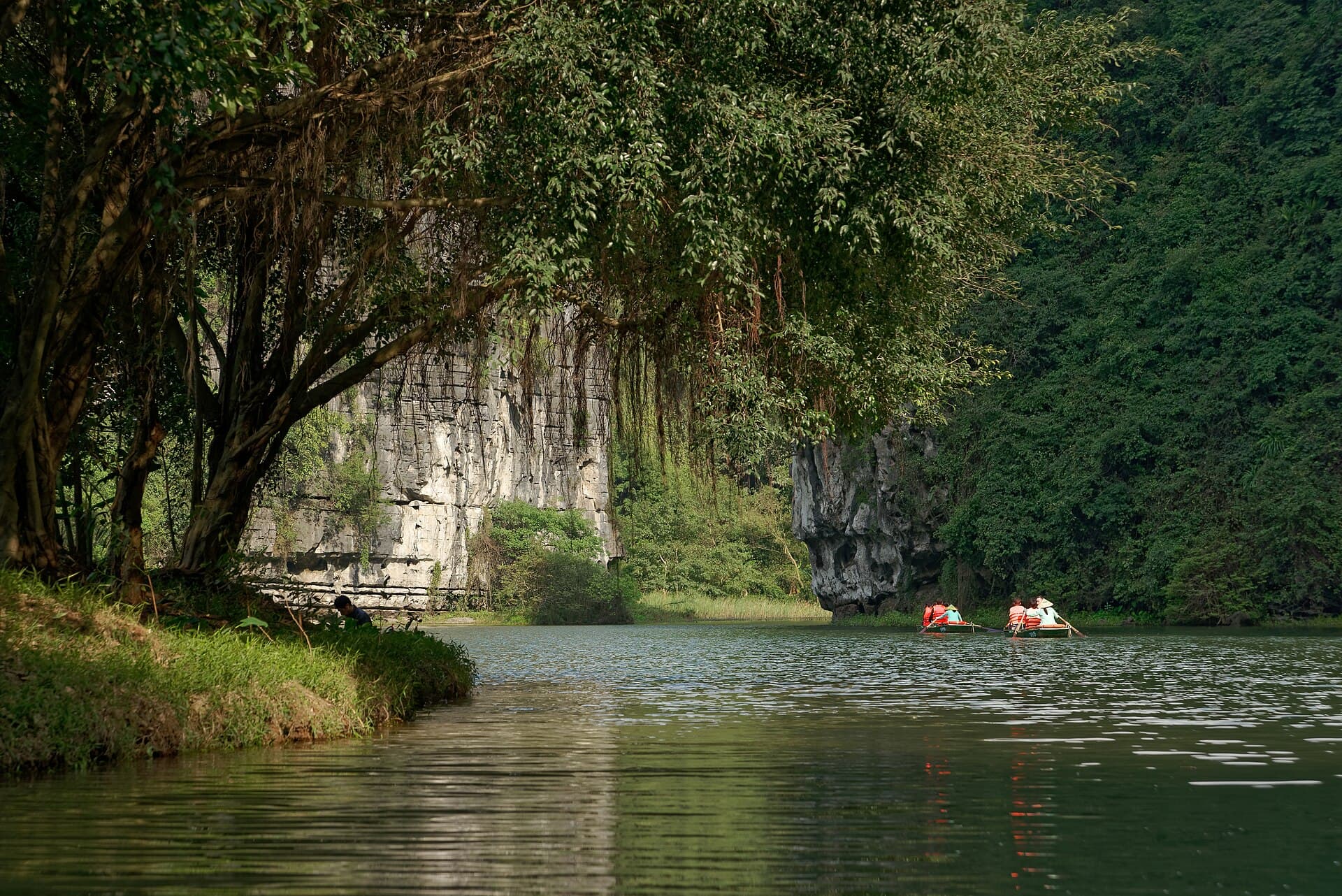 Boats on the river between limestone cliffs at Trang An