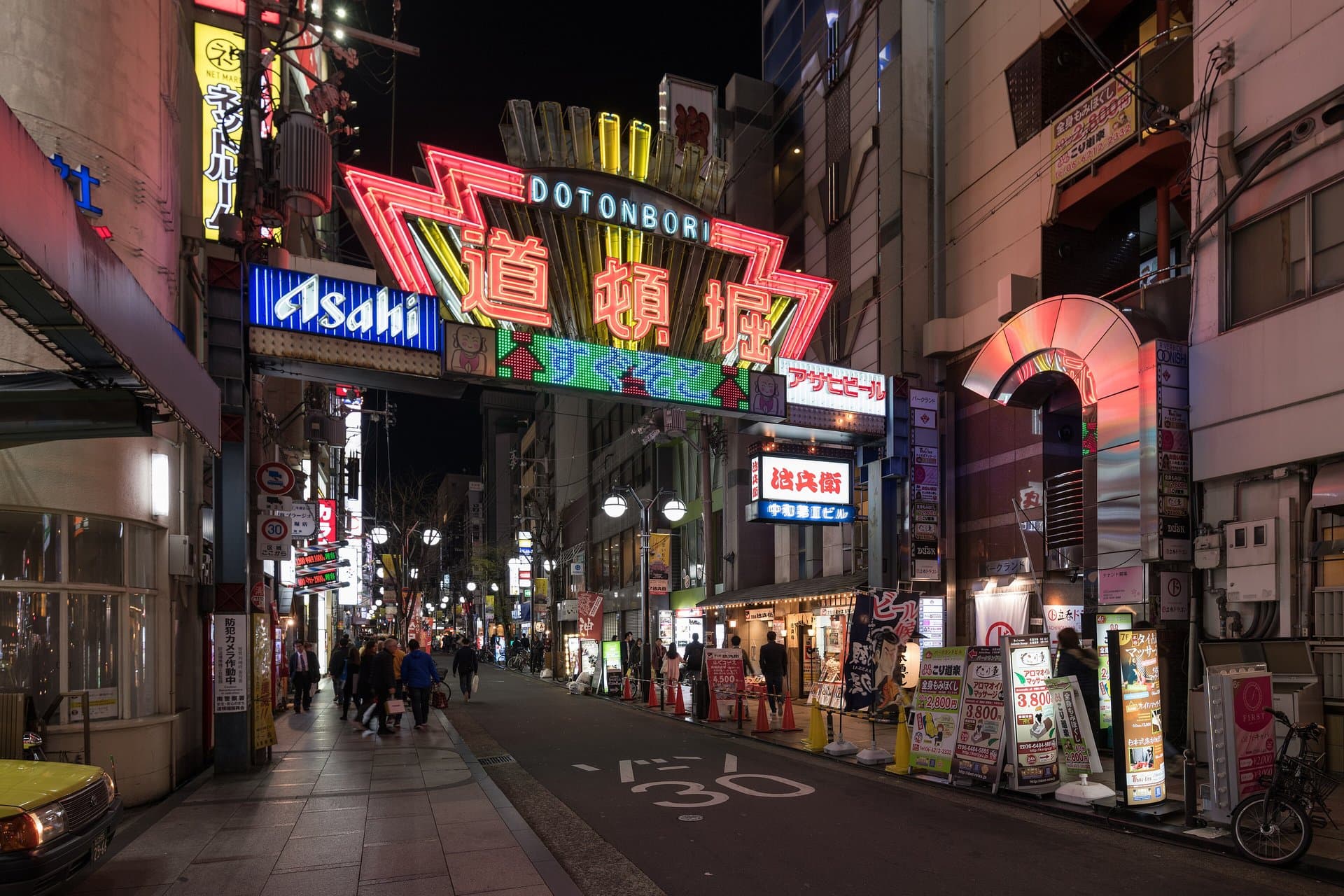 Neon signs over a street in Dotonbori, Osaka, at night