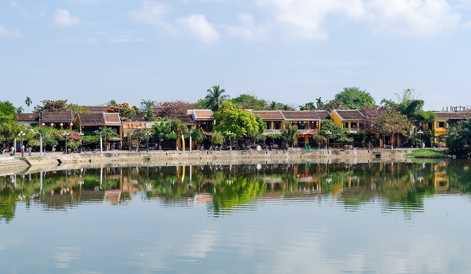 Historic waterfront buildings reflected in the river in Hoi An